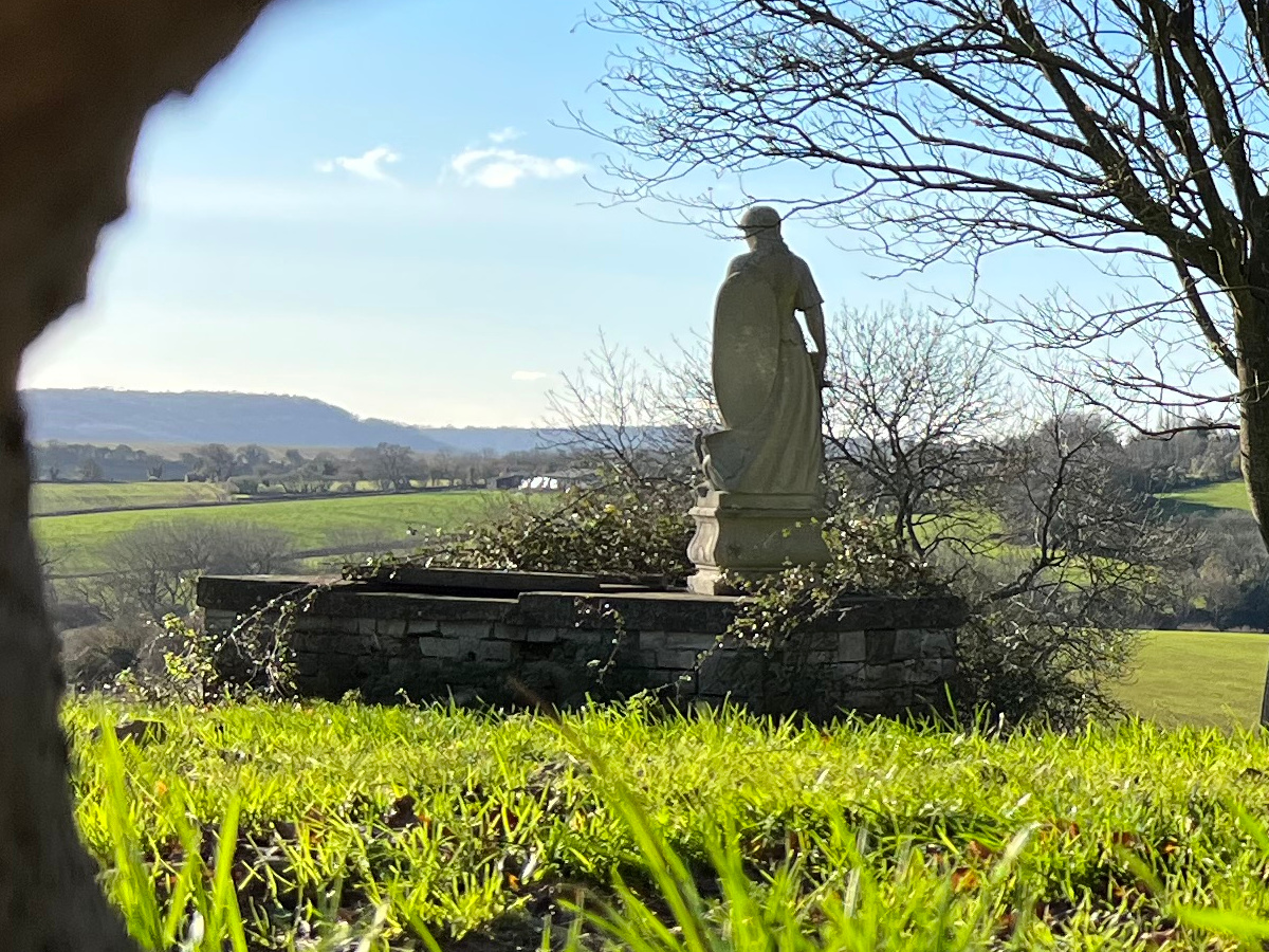 Landscape crop of statue overlooking green hills shot on Apple iPhone 13 Pro Max
