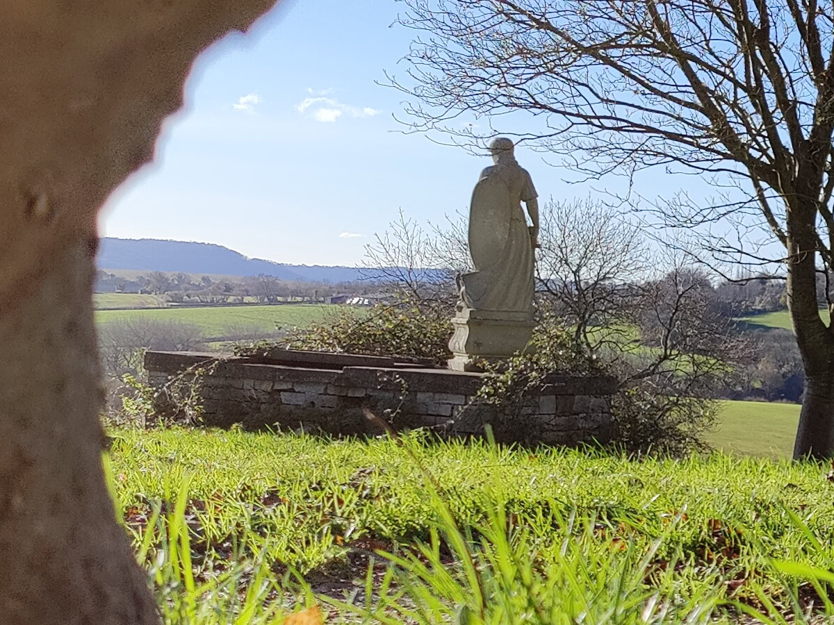 Landscape crop of statue overlooking green hills shot on OnePlus 9 Pro