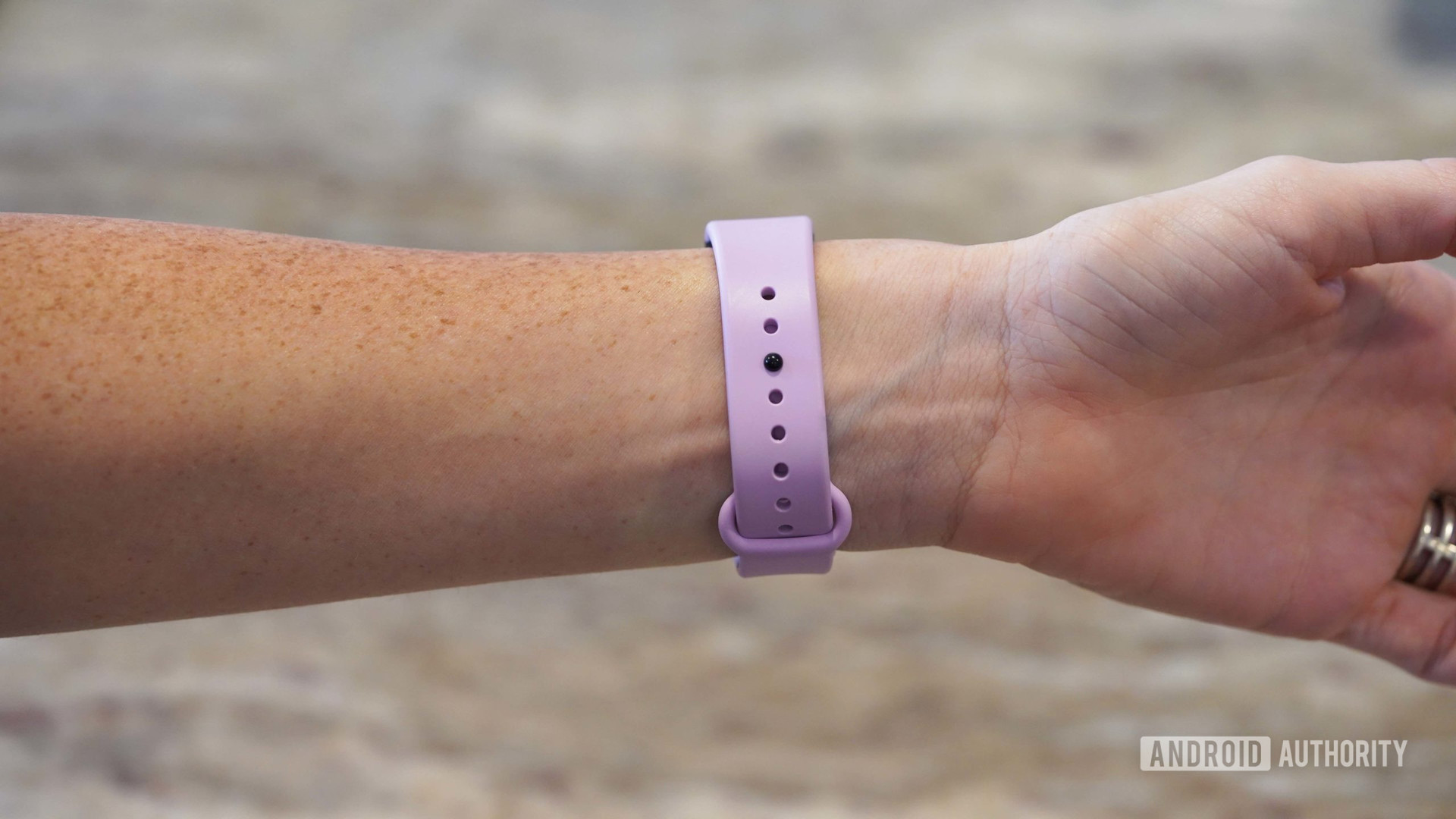 A woman models the strap of an Amazon Halo View in Lavender Dream.
