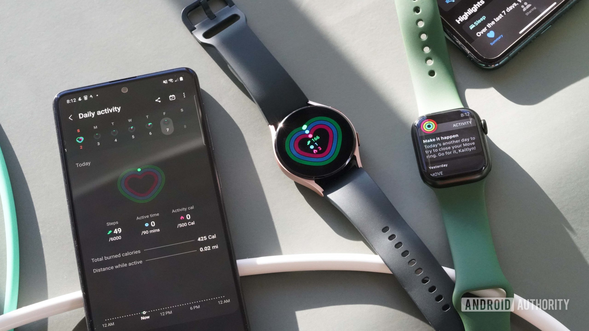 The Samsung Galaxy A51, Samsung Galaxy Watch 4, Apple Watch Series 7, and iPhone 11 sit on a green yoga mat that displays activity-related information or alerts.