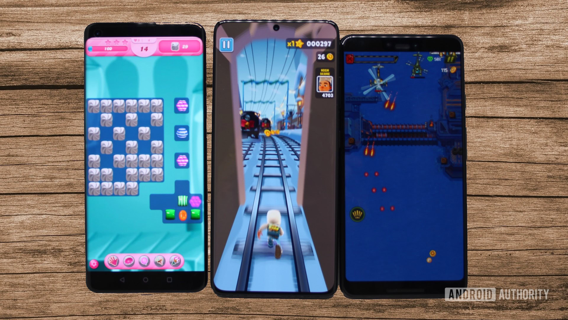 Três telefones Android rodando três jogos com fundo de painel de madeira